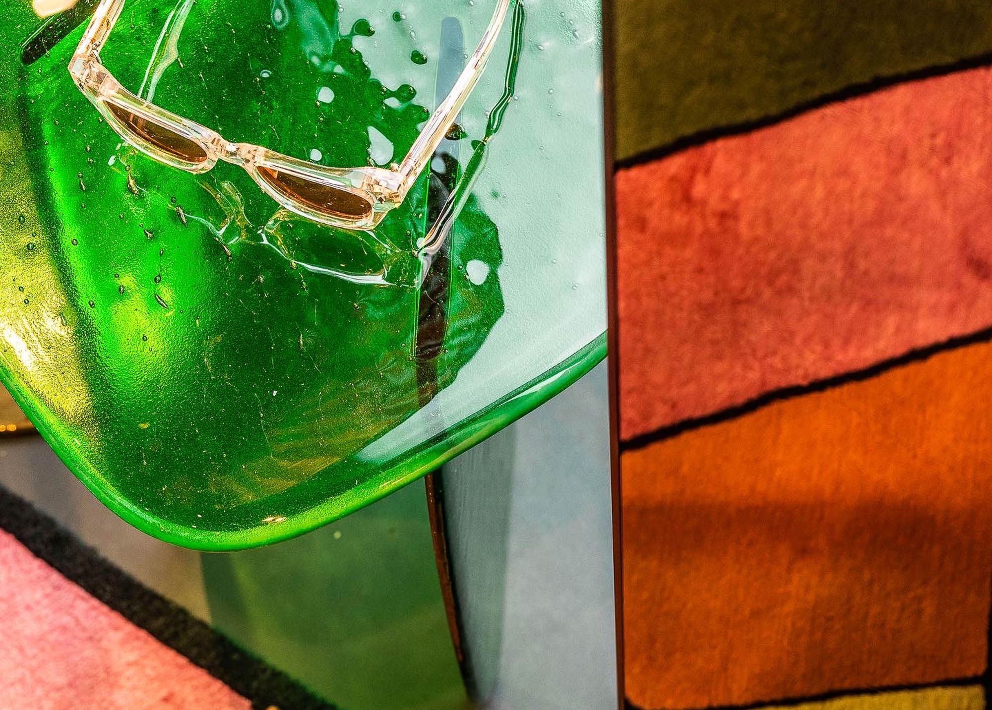 Das kunstvoll inszenierte grüne Glasobjekt mit Sonnenbrille wurde im Leidmann Schaufenster von Stephanie Thatenhorst designt.