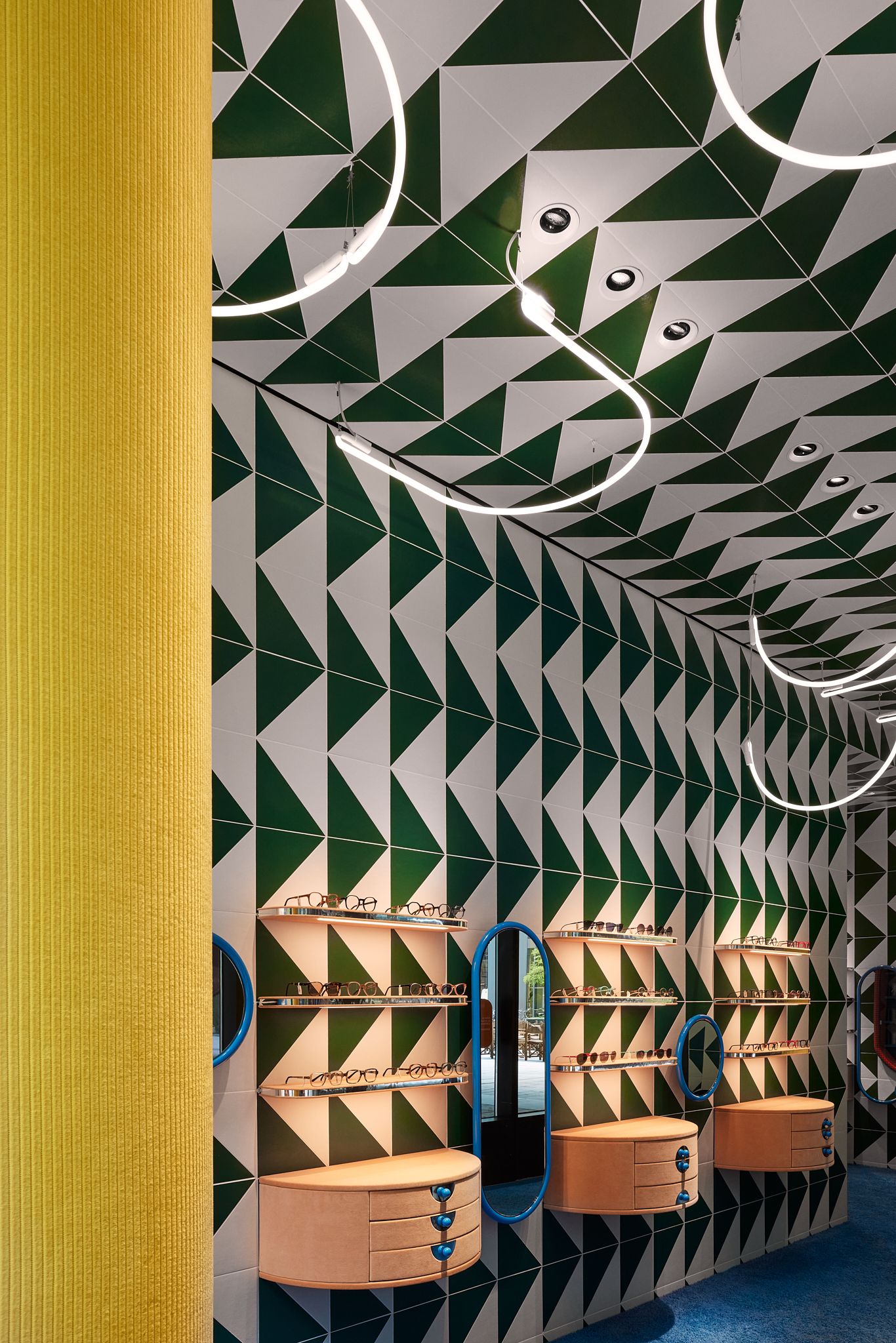 Das Bild zeigt die von Stephanie Thatenhorst entworfene Brillenwand im Rookies – Eyewear for Kids, geprägt von rhythmischen Mustern und farbenfrohen Akzenten.