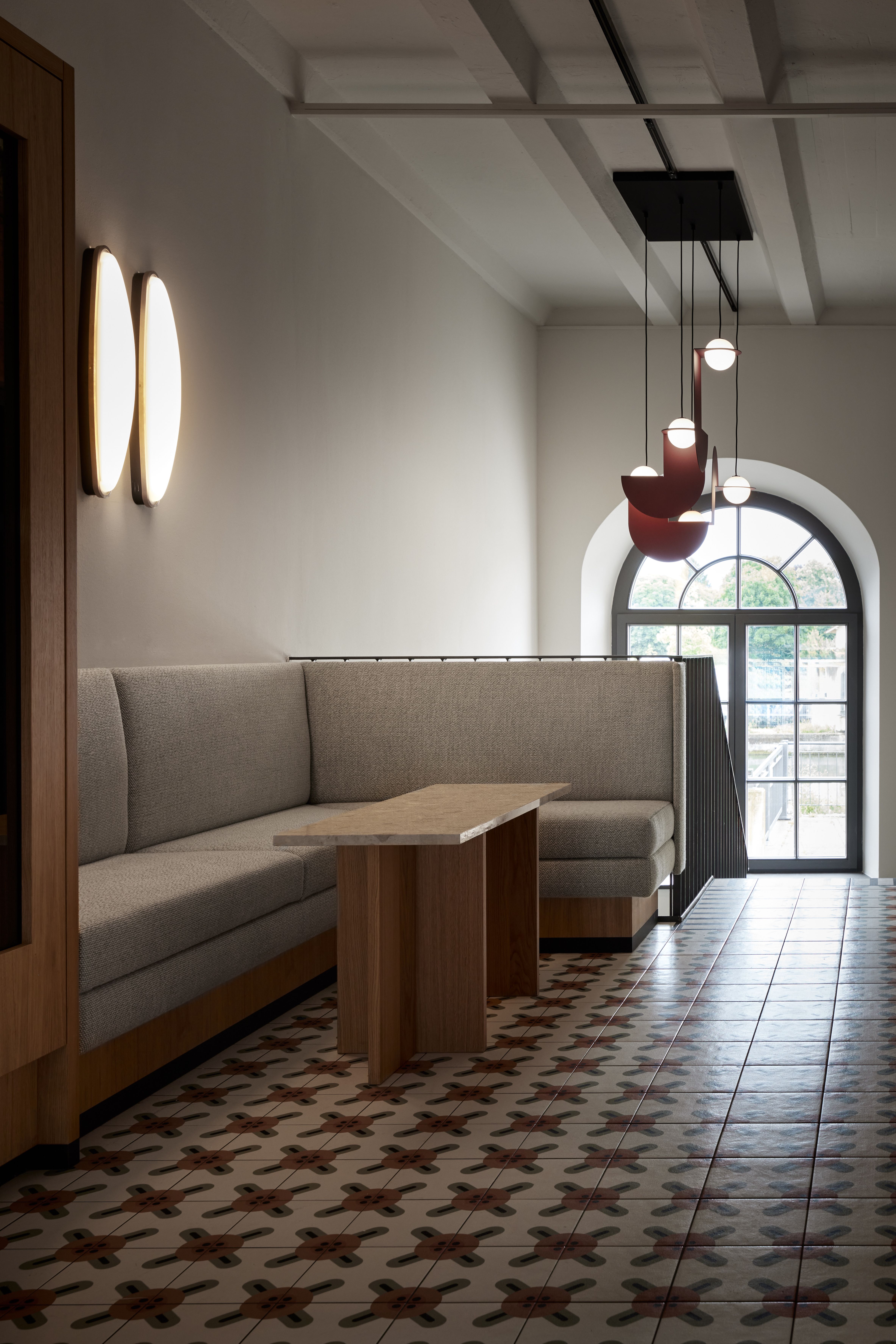 Die erhöhte Sitznische mit skulpturaler Loungebeleuchtung der Brasserie im Turbinenhaus Kolbermoor wurde von Stephanie Thatenhorst als intime Dining-Sphäre innerhalb historischer Werkhallenarchitektur entwickelt.