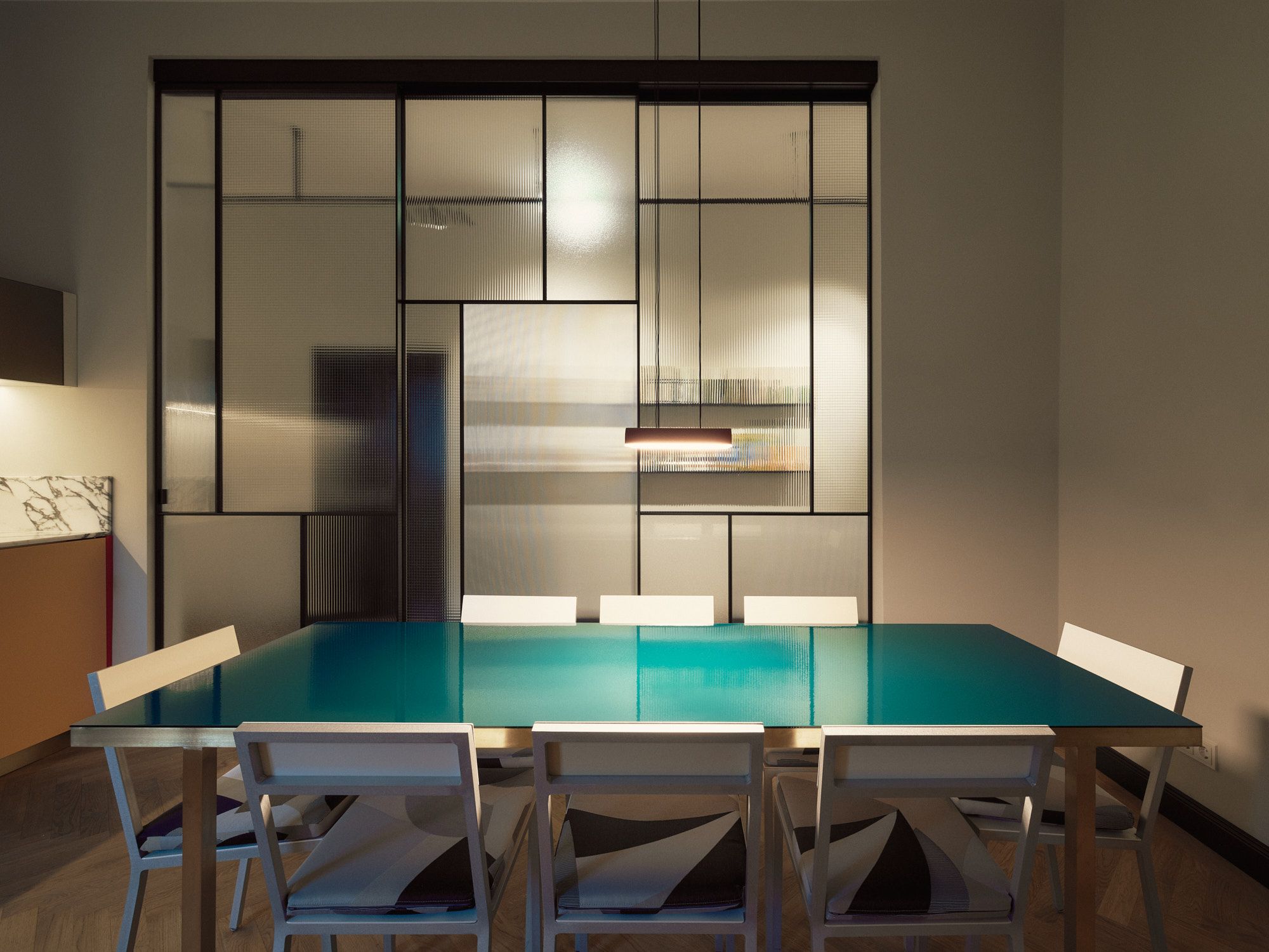 Großzügiger Essbereich mit Glas-Esstisch und Raumteiler, gestaltet von Stephanie Thatenhorst Interior Design.