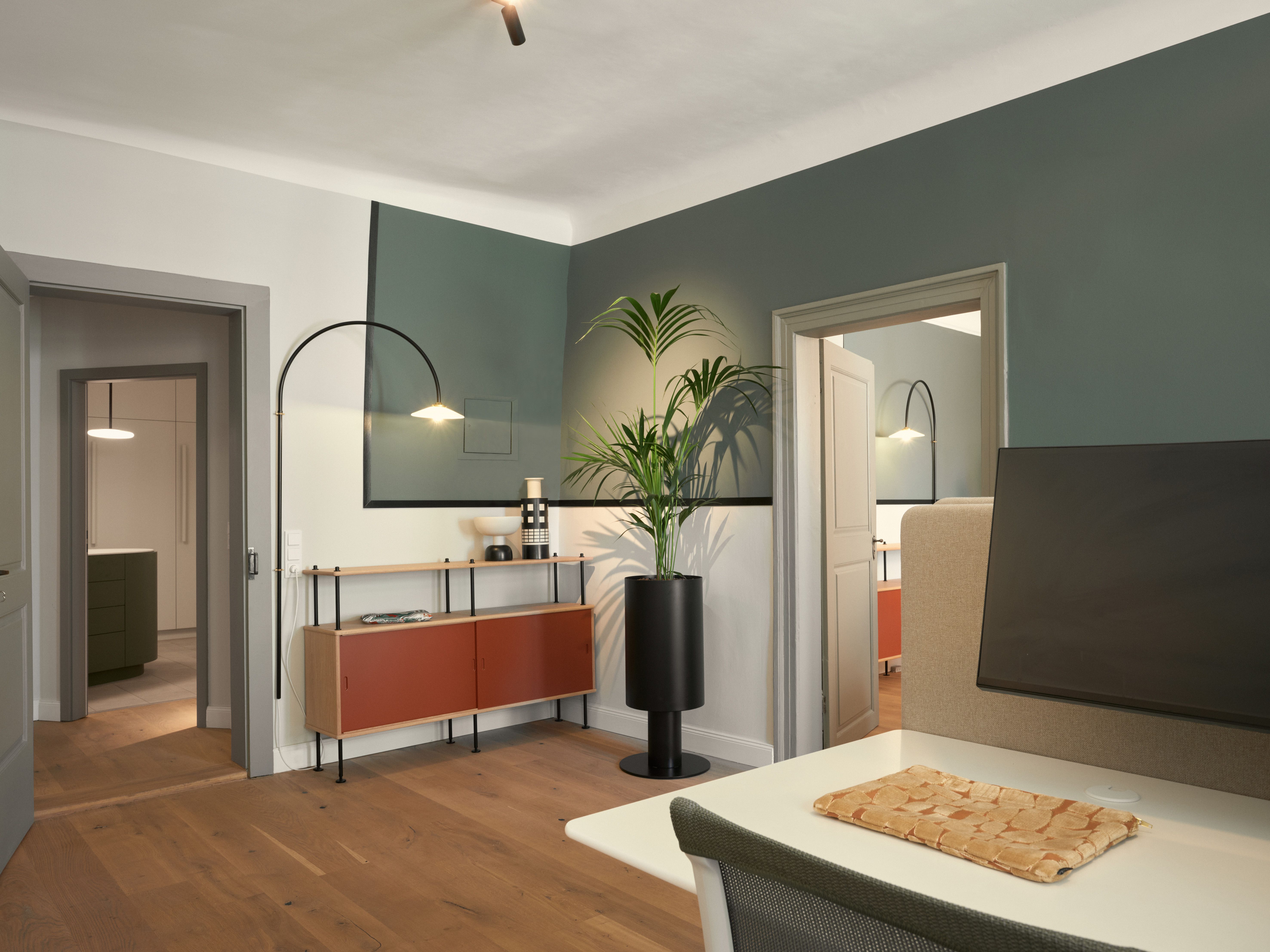 Der Arbeitsplatzbereich mit Akzentwand, großzügiger Bepflanzung und klarer Linienführung wurde von Stephanie Thatenhorst für das Summa Equity Büro München geplant.