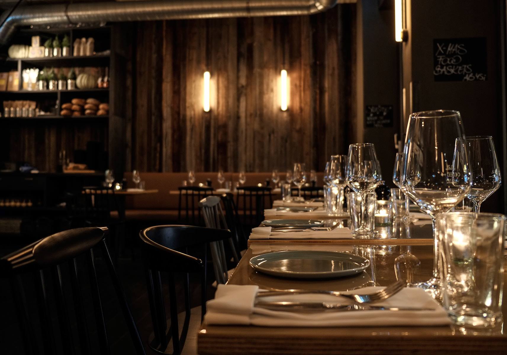 Der Gastraum des Occam Deli überzeugt durch warmes Licht, dunkle Holzoberflächen und eine intime Atmosphäre mit handwerklichem Charakter.