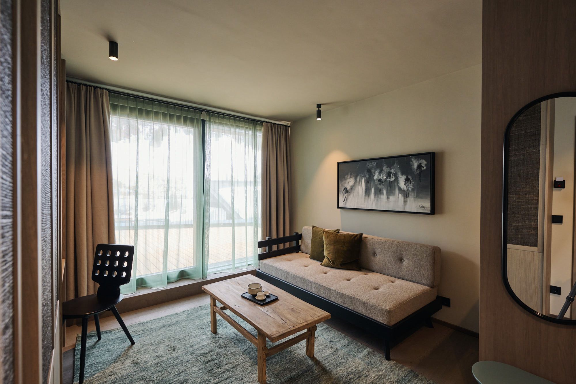 Die lichtdurchflutete Wohnzone im Ullrhaus Hotel trägt Stephanie Thatenhorsts unverwechselbare Handschrift durch hochwertige Stoffe und ruhige Farbwelten.