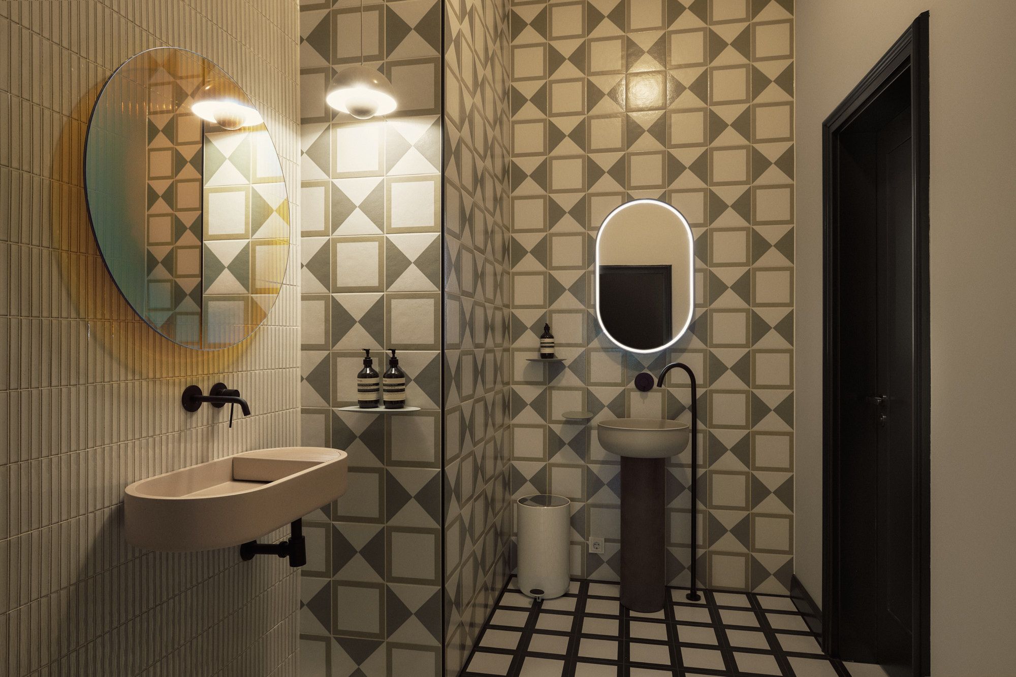 Zeitloses Bad mit grafischen Fliesen, maßgefertigten Waschtischen und Lichtkonzept von Stephanie Thatenhorst Interior Design.