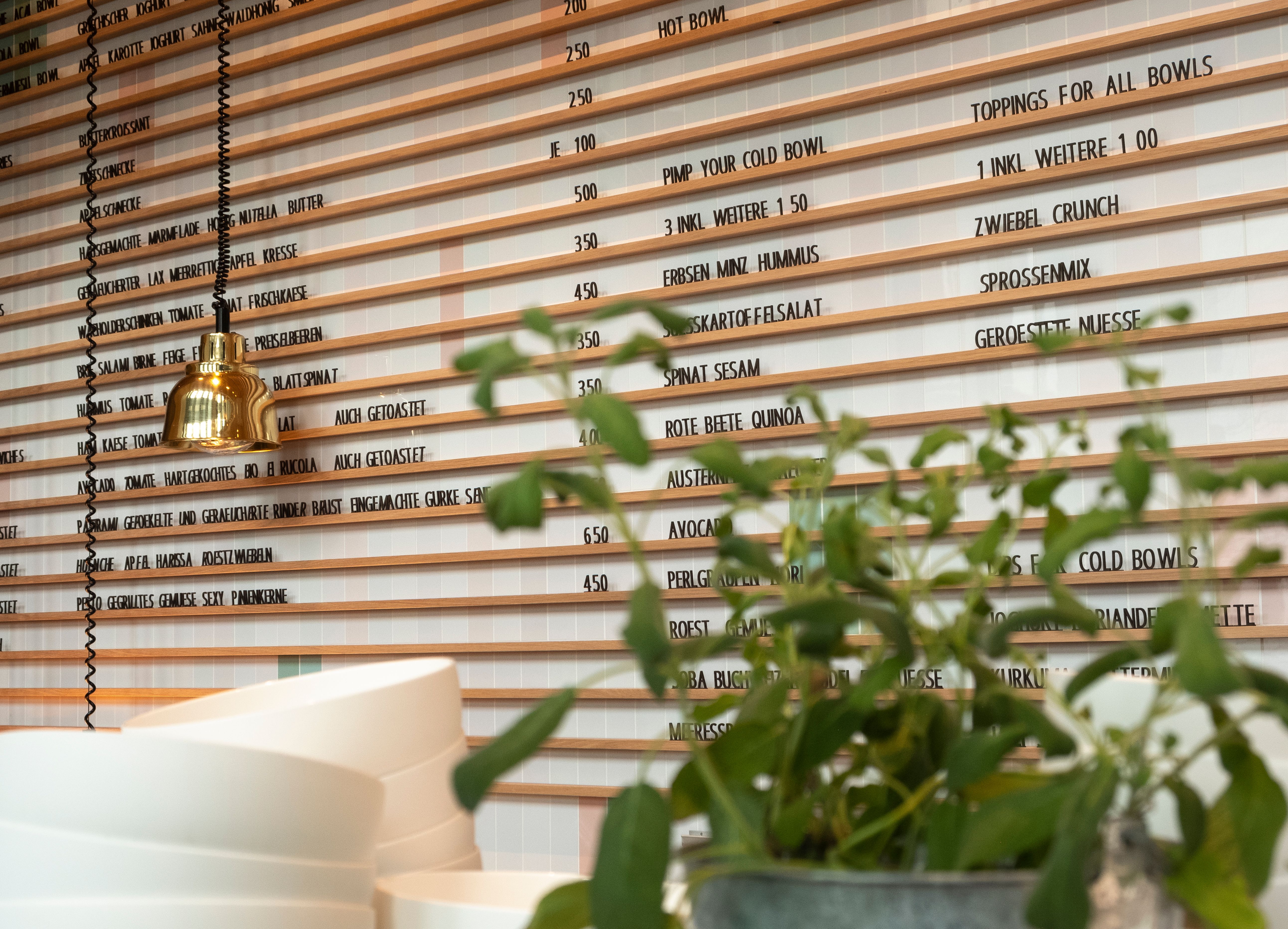 Die klar strukturierte Menüwand im Lilli P ist Teil des funktionalen und gleichzeitig ästhetisch durchdachten Interior-Designs von Stephanie Thatenhorst.