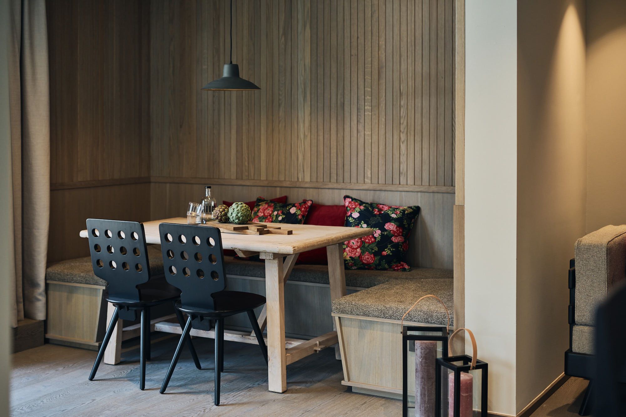 Die gemütliche Essecke im Ullrhaus, entworfen von Stephanie Thatenhorst, kombiniert florale Akzente mit klarer Holzarchitektur.