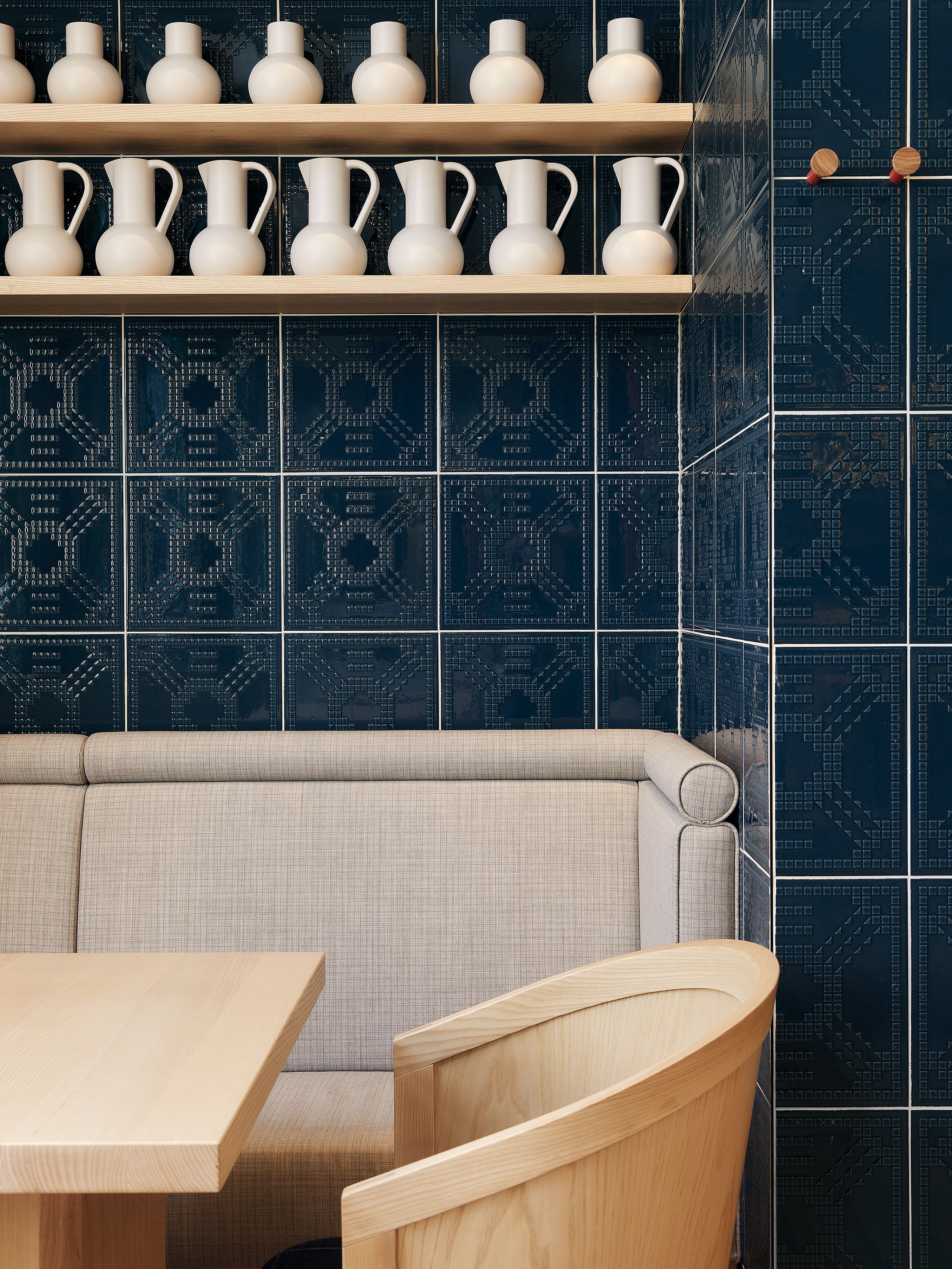 Maßgefertigte Sitzmöbel und massive Holztische prägen den Gastraum des Benediktiner Weissbräuhauses und verbinden zeitgemäßes Restaurantdesign mit traditioneller Wirtshauskultur.