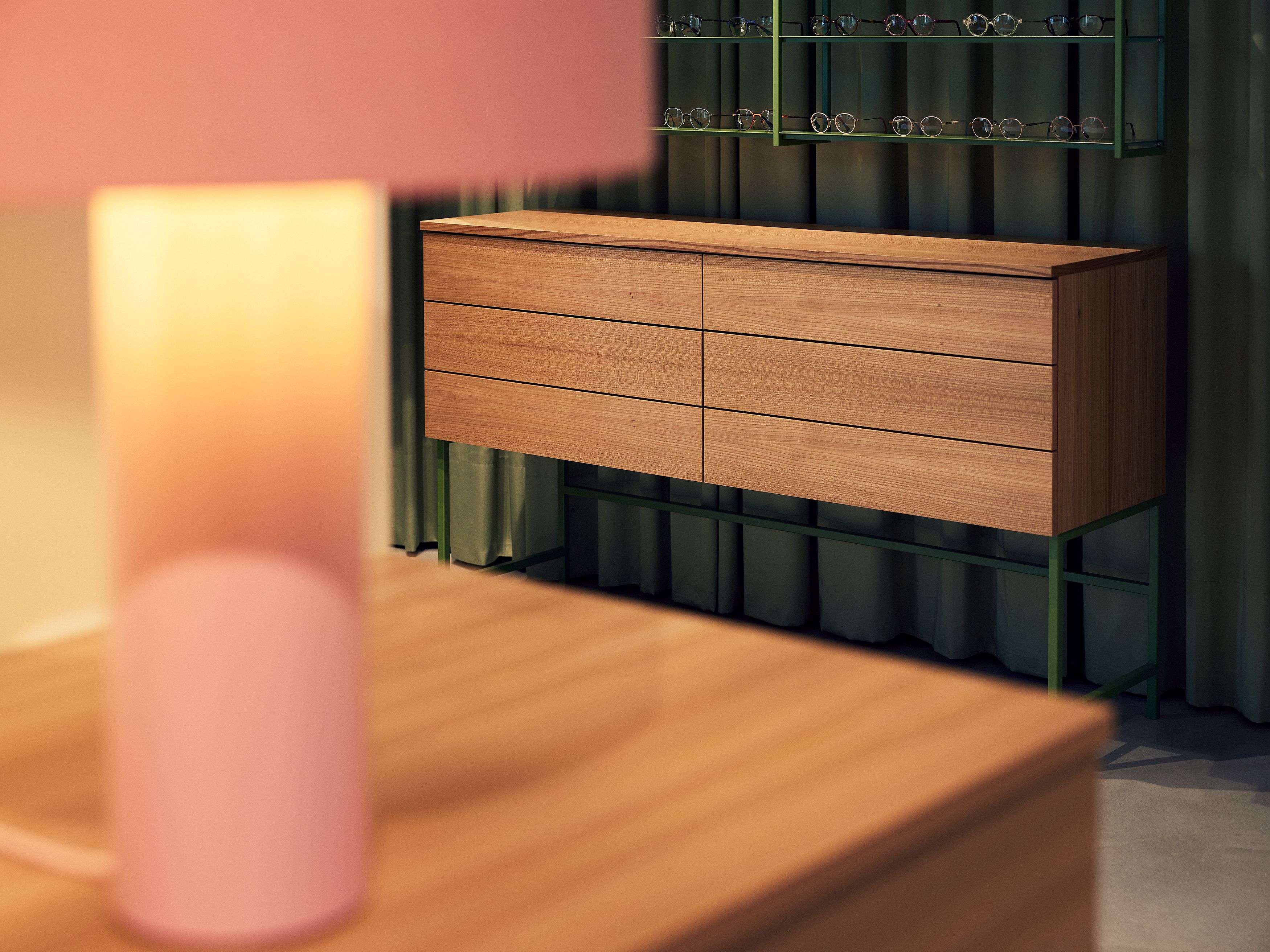 Die minimalistische Kommode hinter samtigem Vorhang wurde von Stephanie Thatenhorst für Christian Bartels Optik designt.