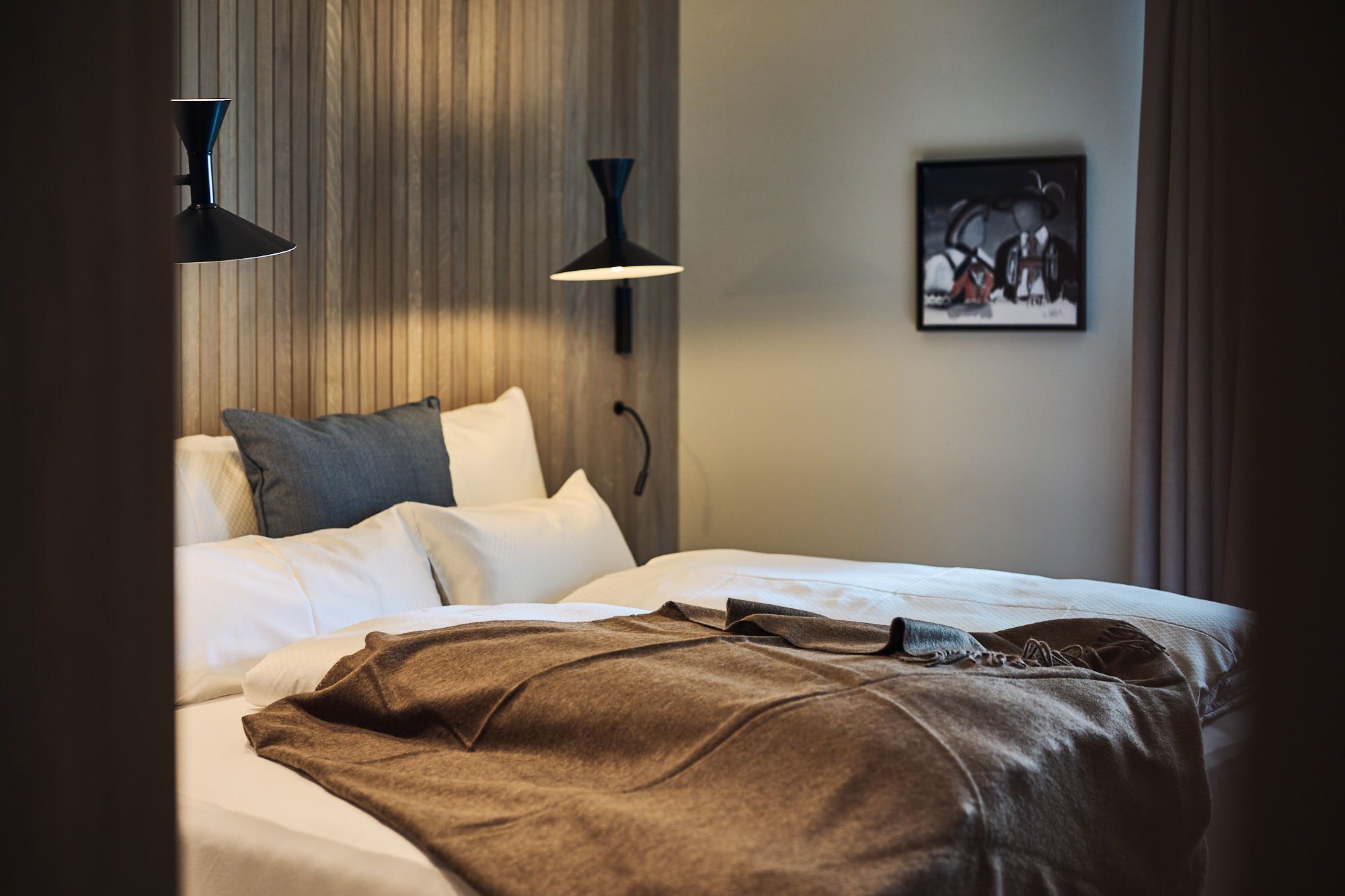 Das Schlafzimmer im Ullrhaus – Hotel präsentiert Stephanie Thatenhorsts klaren, alpinen Designansatz mit warmen Texturen.