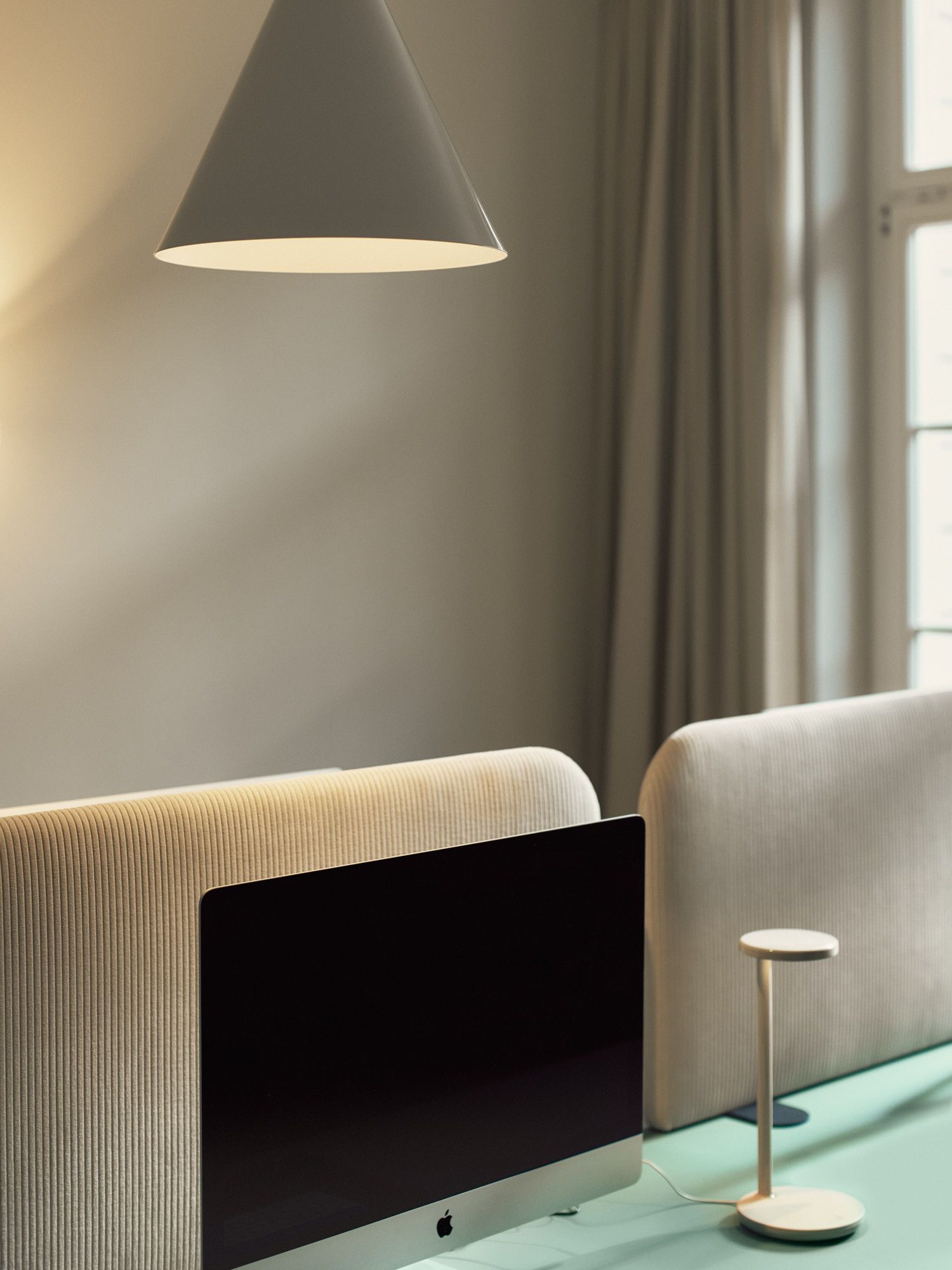 Ruhiger Arbeitsplatz mit reduziertem Möbeldesign und Lichtakzenten von Stephanie Thatenhorst Interior Design.