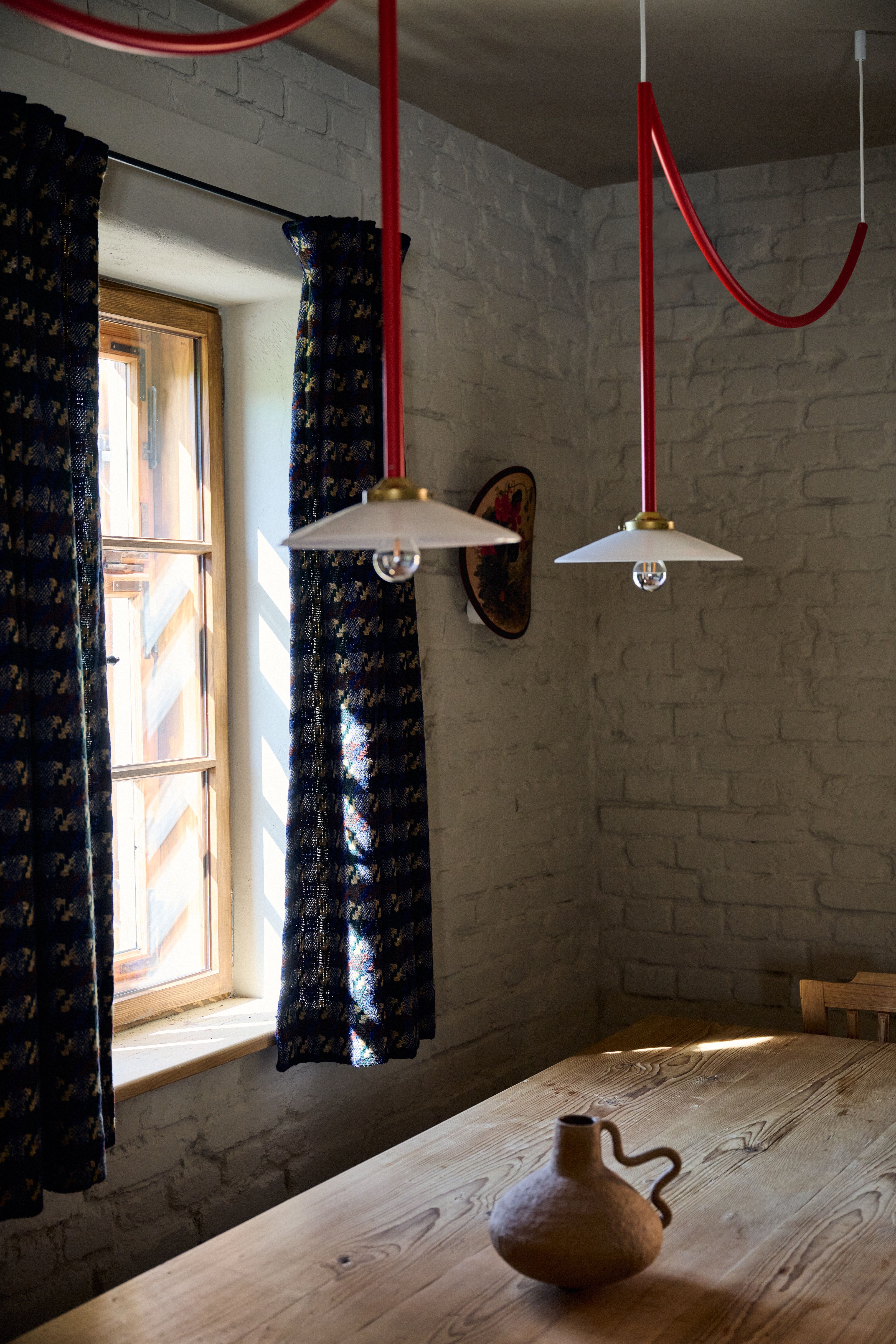 Vorhangdetail und rote Pendelleuchten im Landhausinterior, designed by Stephanie Thatenhorst
