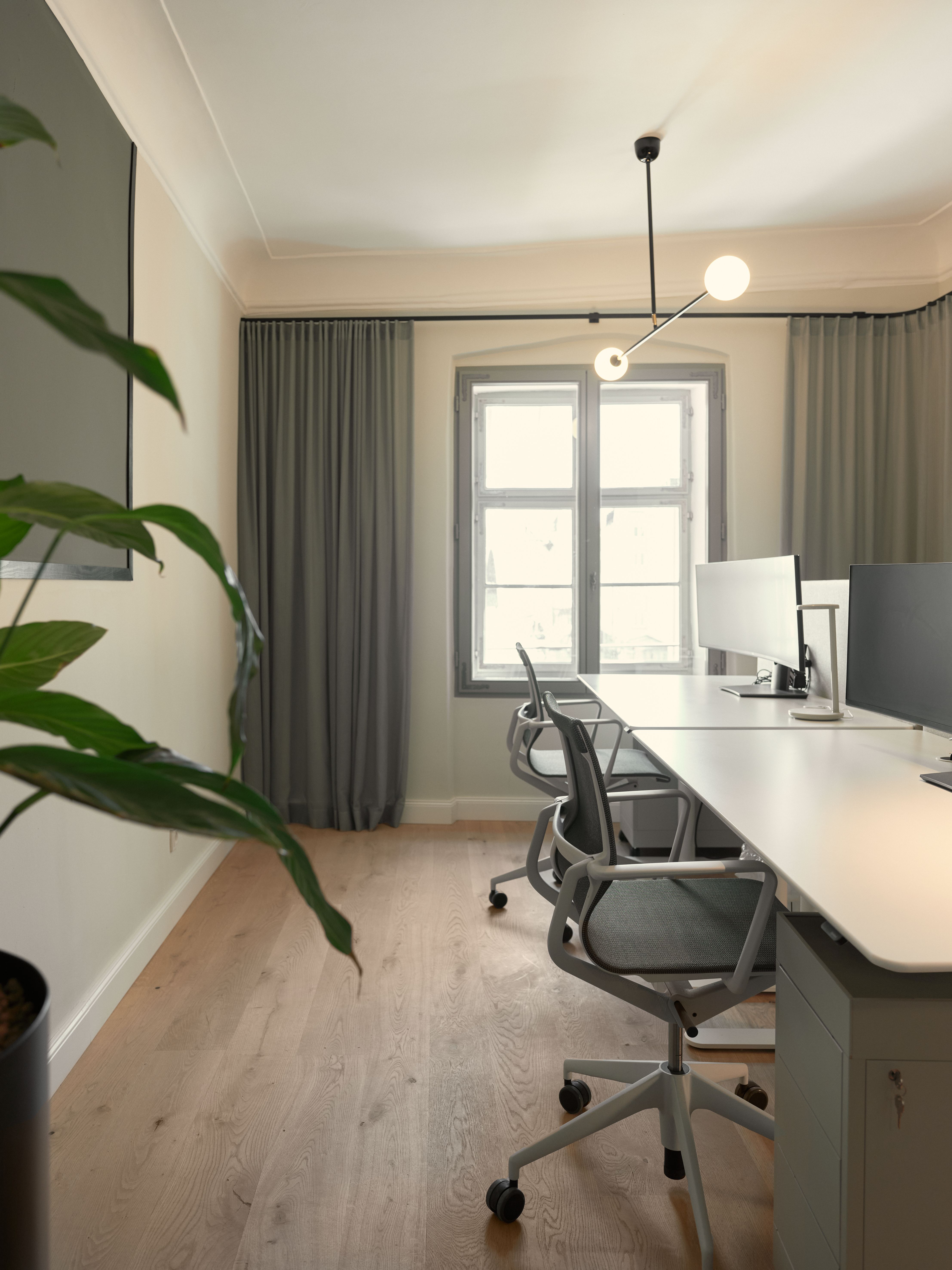 Der helle Office-Arbeitsraum mit linearen Leuchten und ruhigen Farbflächen wurde von Stephanie Thatenhorst im Summa Equity Büro München gestaltet.
