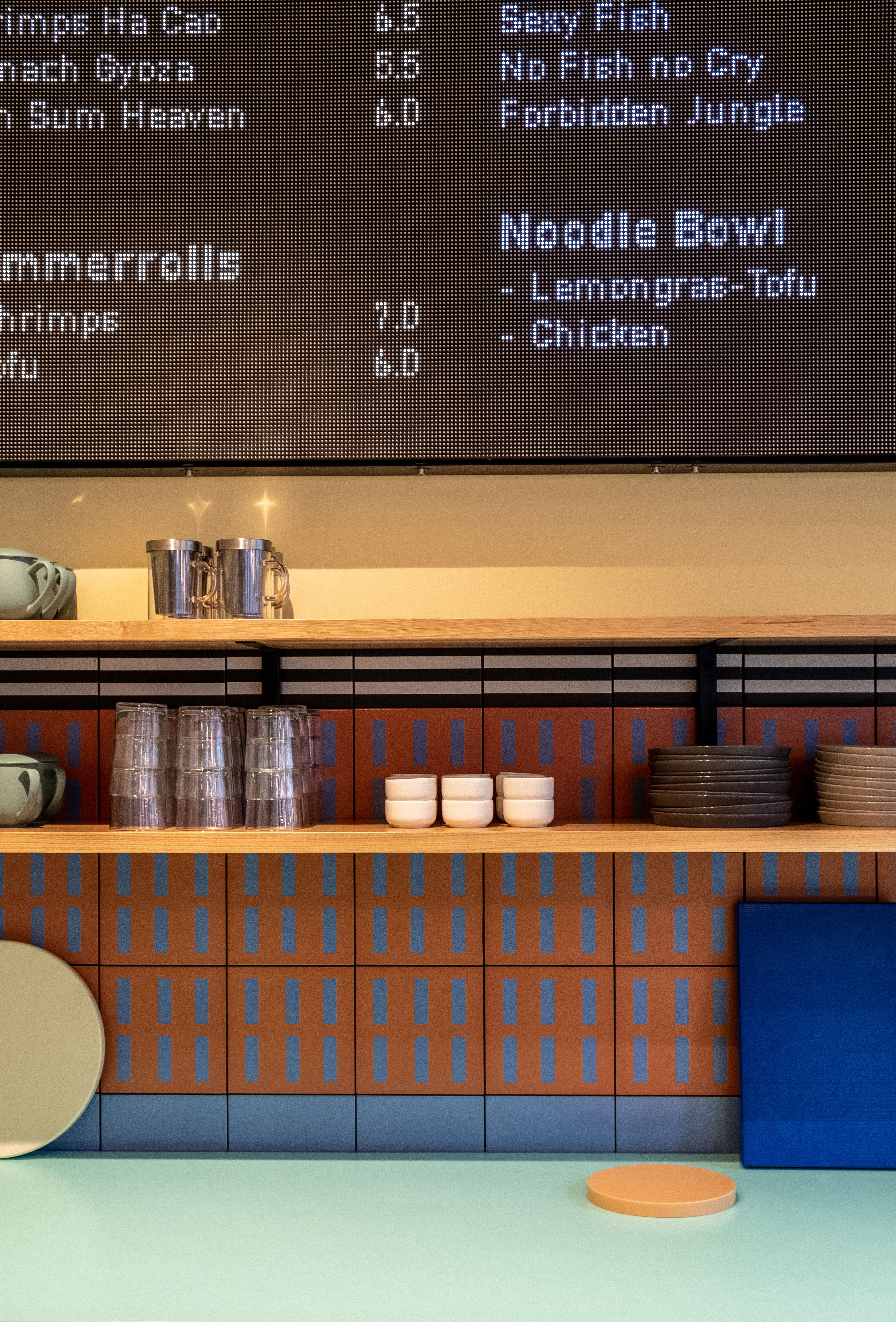 Farbenfrohe Akzente und präzise ausgeführte Fliesenarbeiten prägen das visuelle Erscheinungsbild des Tresenbereichs im By Vu – Asian Restaurant.