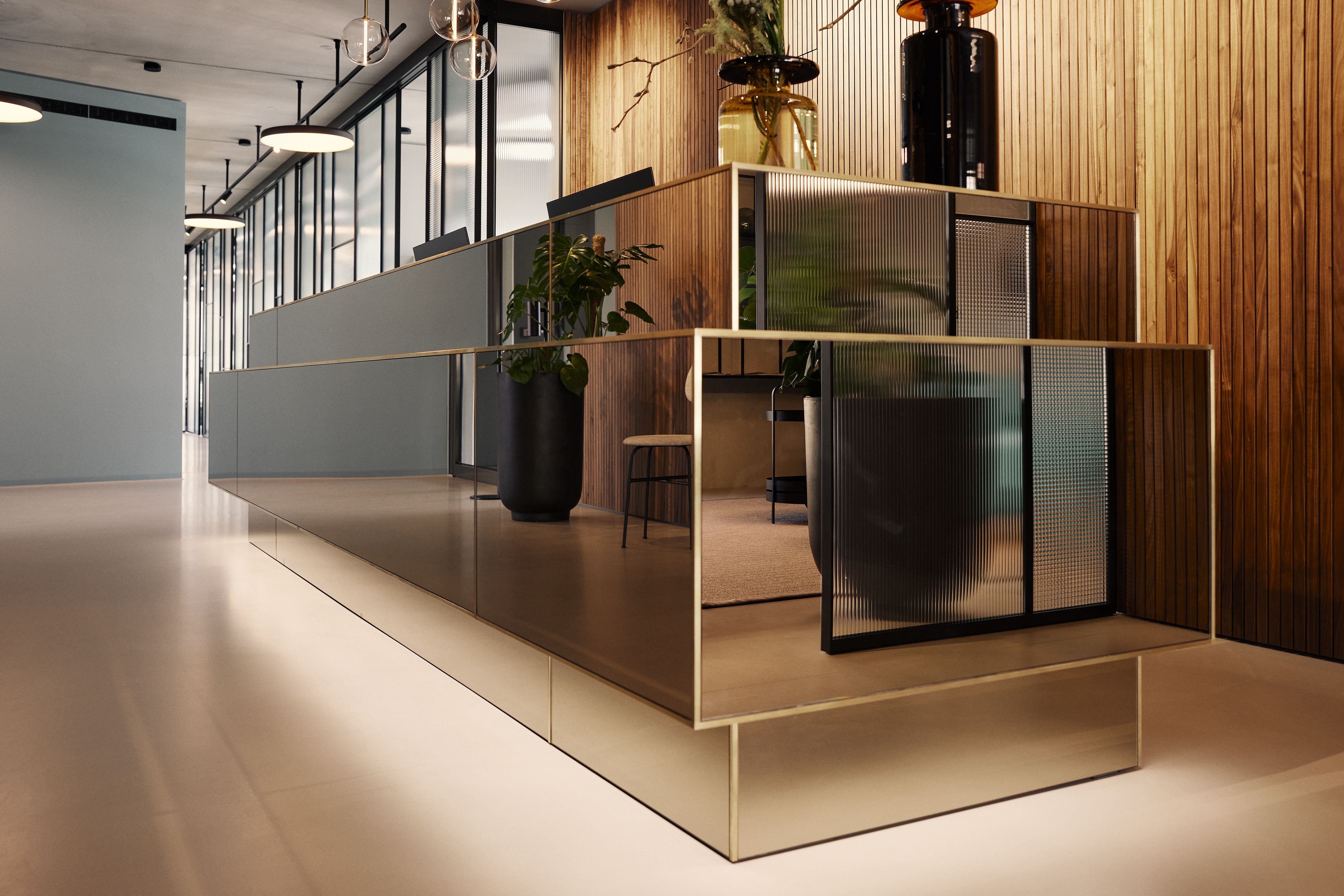 Der moderne Empfangsbereich der Zahnarztpraxis Kempten verbindet hochwertige Materialien mit klarer Linienführung und schafft eine vertrauensvolle Atmosphäre.