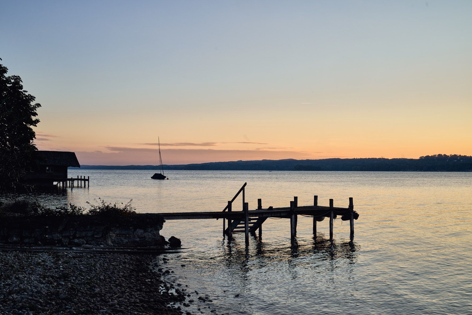 Stimmungsvolle Seeaufnahme mit historischem Steg und sanfter Abendsonne für ein ruhiges, naturnahes und atmosphärisches Ambiente