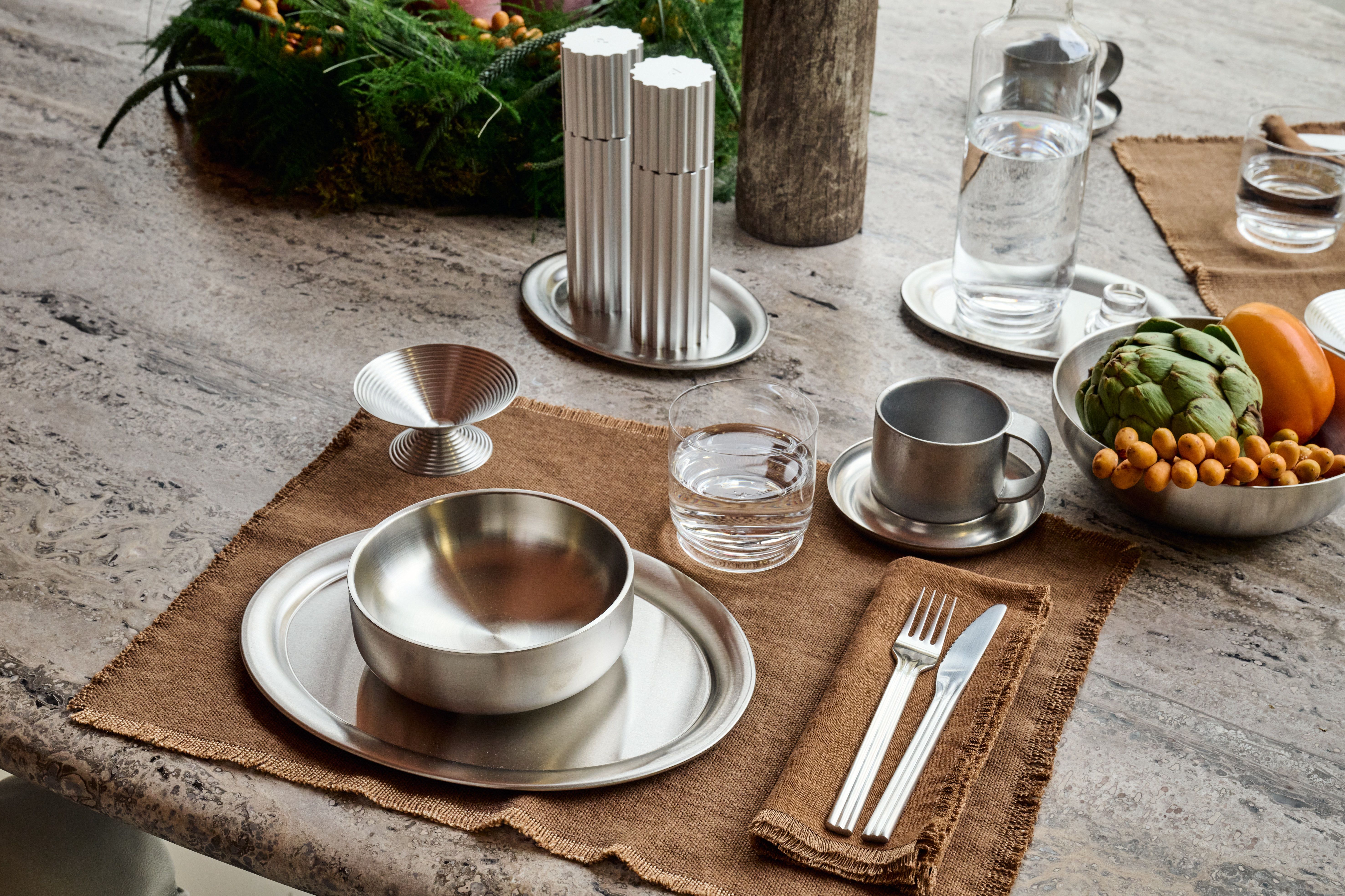 Ein farbenfrohes Blumenarrangement in einer markanten, rot-weiß gestreiften Designer-Vase setzt einen lebendigen, modernen Akzent im Interieur.