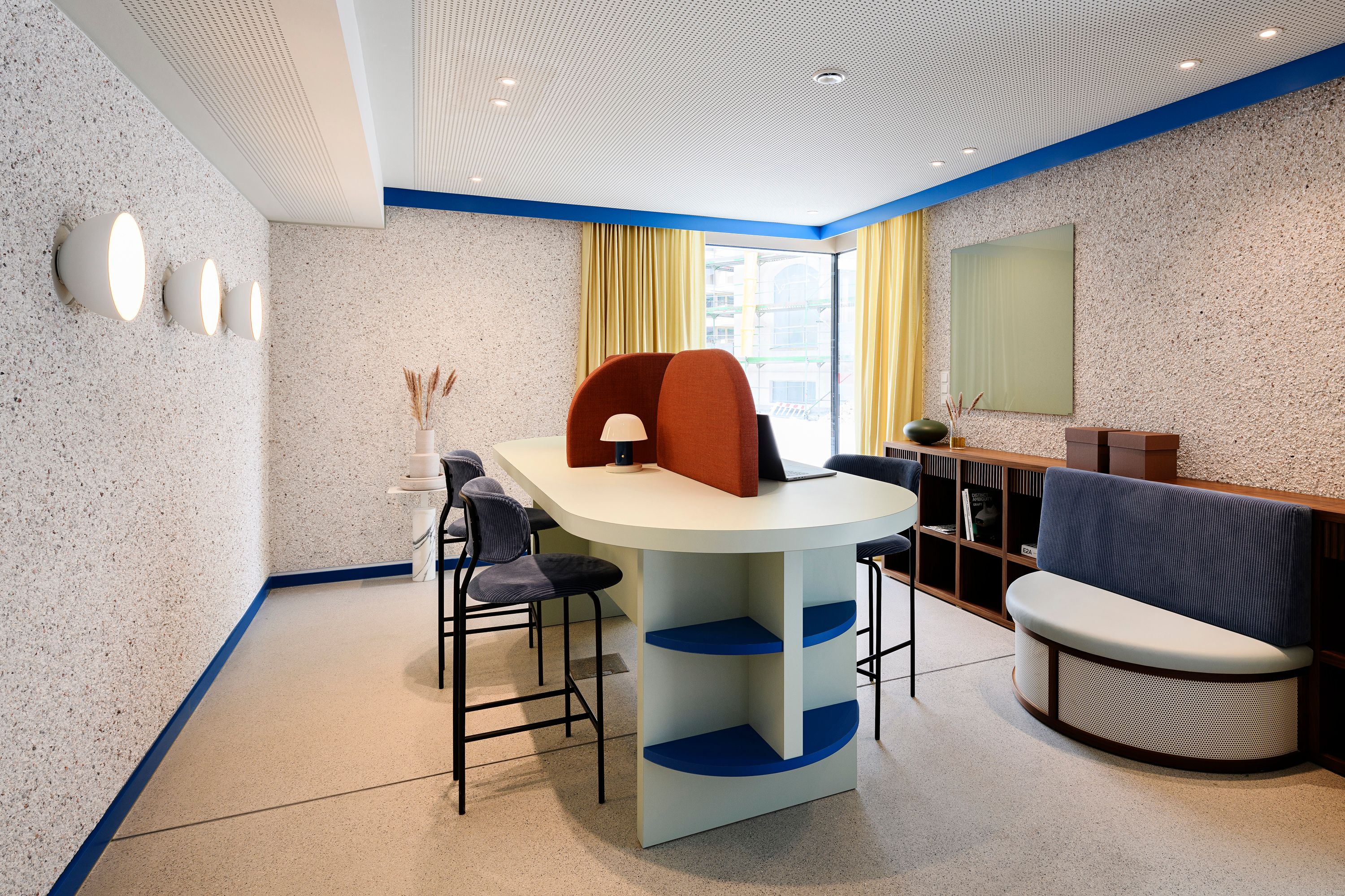 Die zentrale Working-Area mit ovalem Tisch und farbigen Raumteilern wurde von Stephanie Thatenhorst designt und strukturiert die Kupa – Kitchen & Working Lounge funktional und stilvoll.