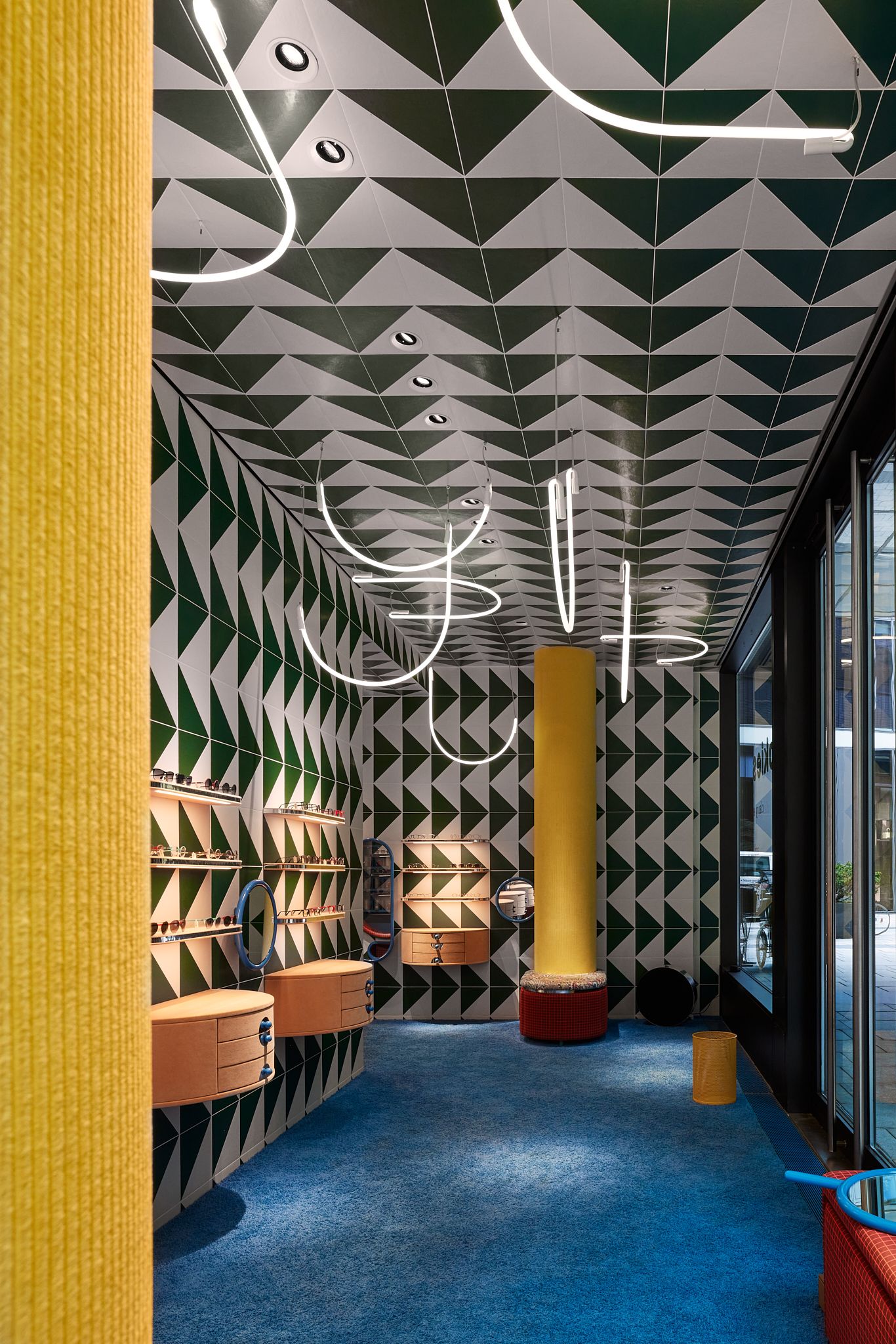 Die offene Eingangssituation des Rookies – Eyewear for Kids, gestaltet von Stephanie Thatenhorst, setzt mit grafischen Wandfliesen und harmonischer Beleuchtung ein kraftvolles Designstatement.