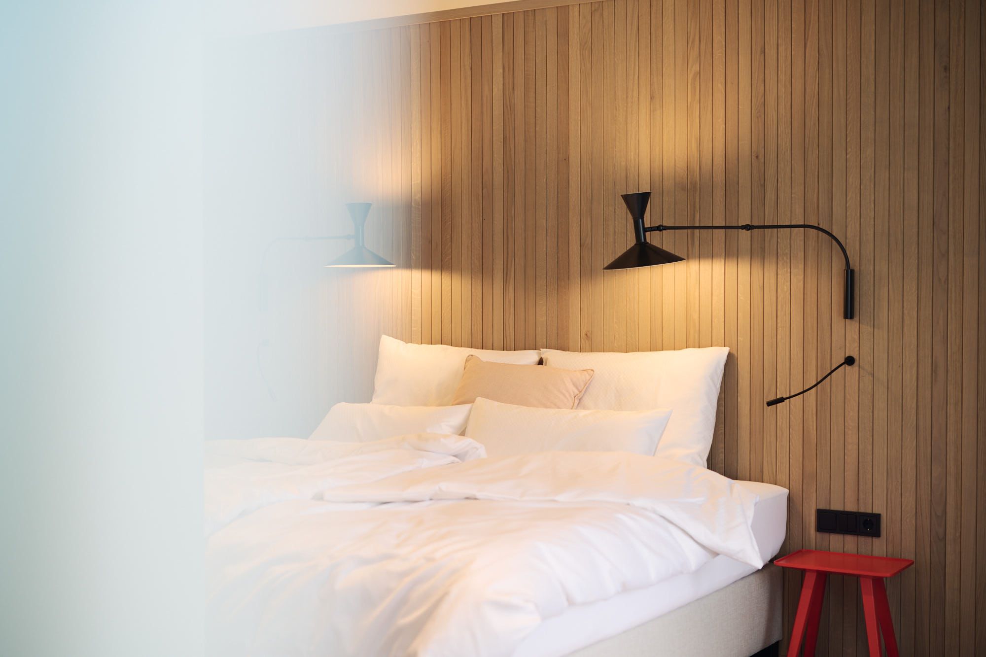 Stephanie Thatenhorst inszeniert im Ullrhaus Hotel ein warmes Schlafzimmerambiente, das durch weiche Textilien und klare Linien zeitlose Eleganz ausstrahlt.