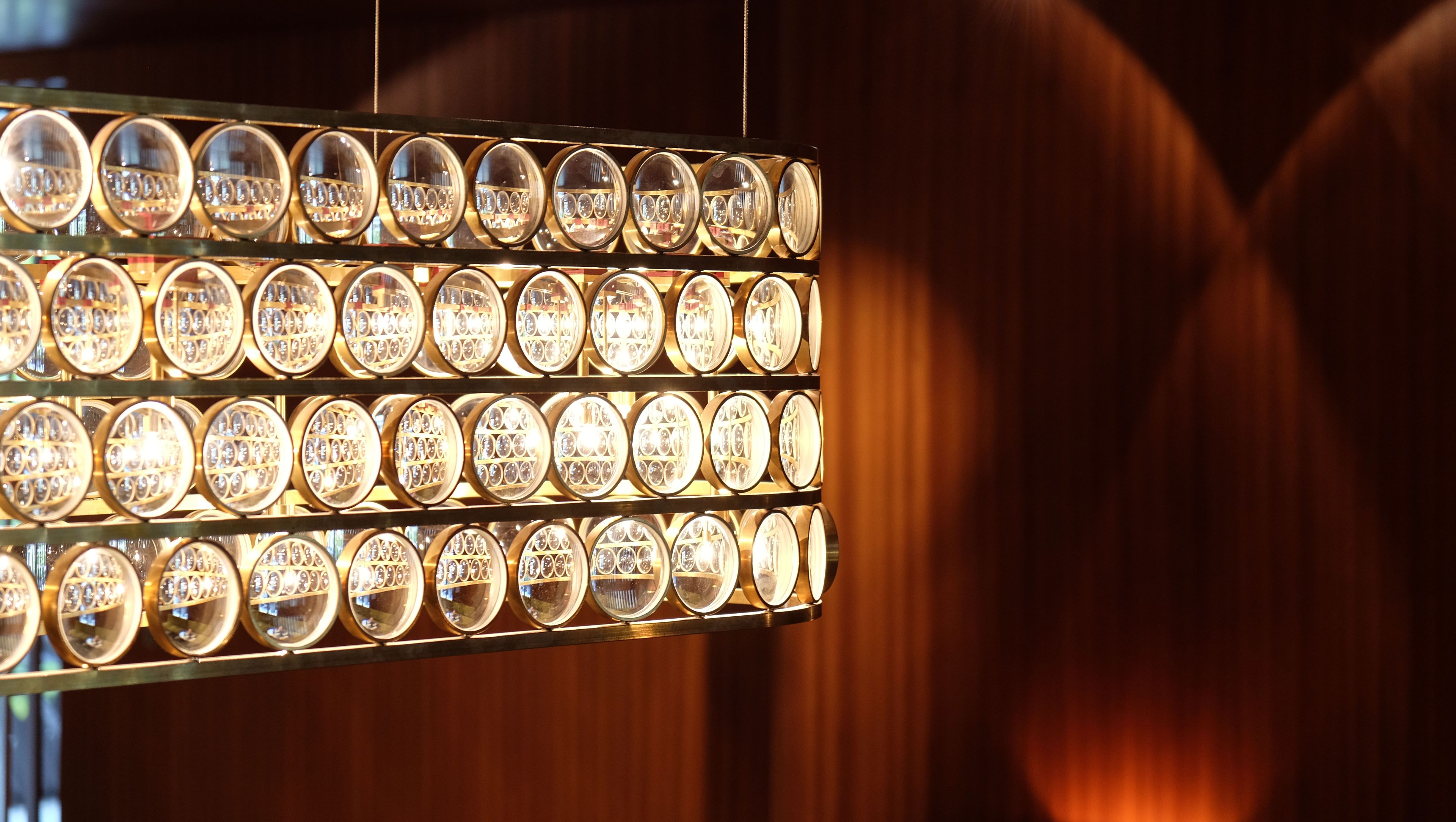 Die ikonische Leuchte mit Messingringen setzt im Theresa – Restaurant Bar, gestaltet von Stephanie Thatenhorst, ein prägnantes Statement für luxuriöses Lichtdesign.