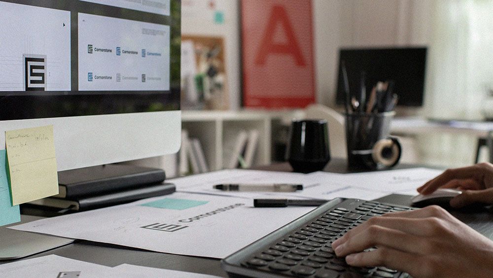 Designer creating visual brand assets at a studio workstation