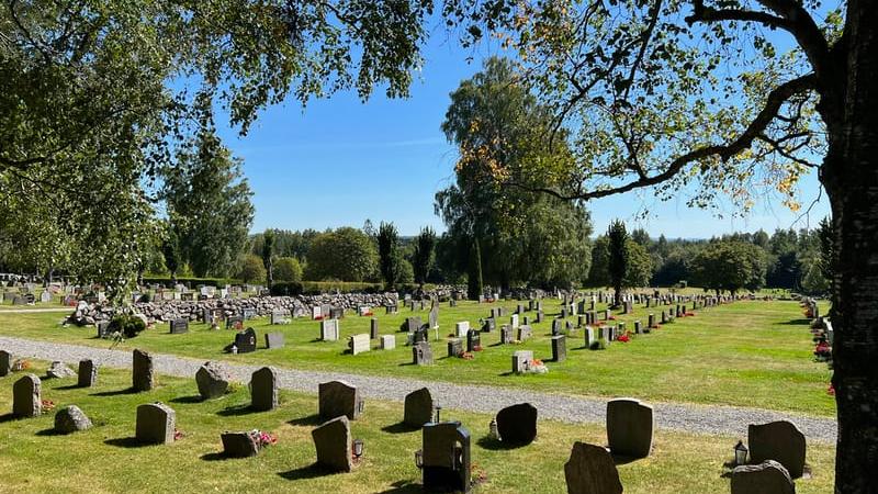 Kyrkogård med gravstenar en sommardag