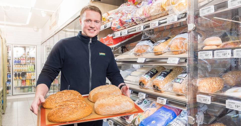 En Joker-ansatt viser frem nybakt brød