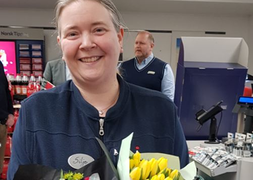 Silje fra Joker Kongsvinger holder en blomsterbukett inne i dagligvarebutikken
