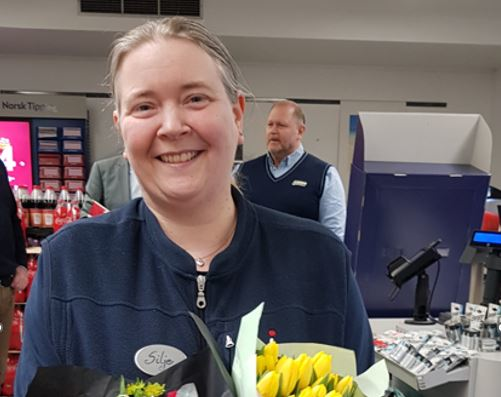 Silje fra Joker Kongsvinger holder en blomsterbukett inne i dagligvarebutikken