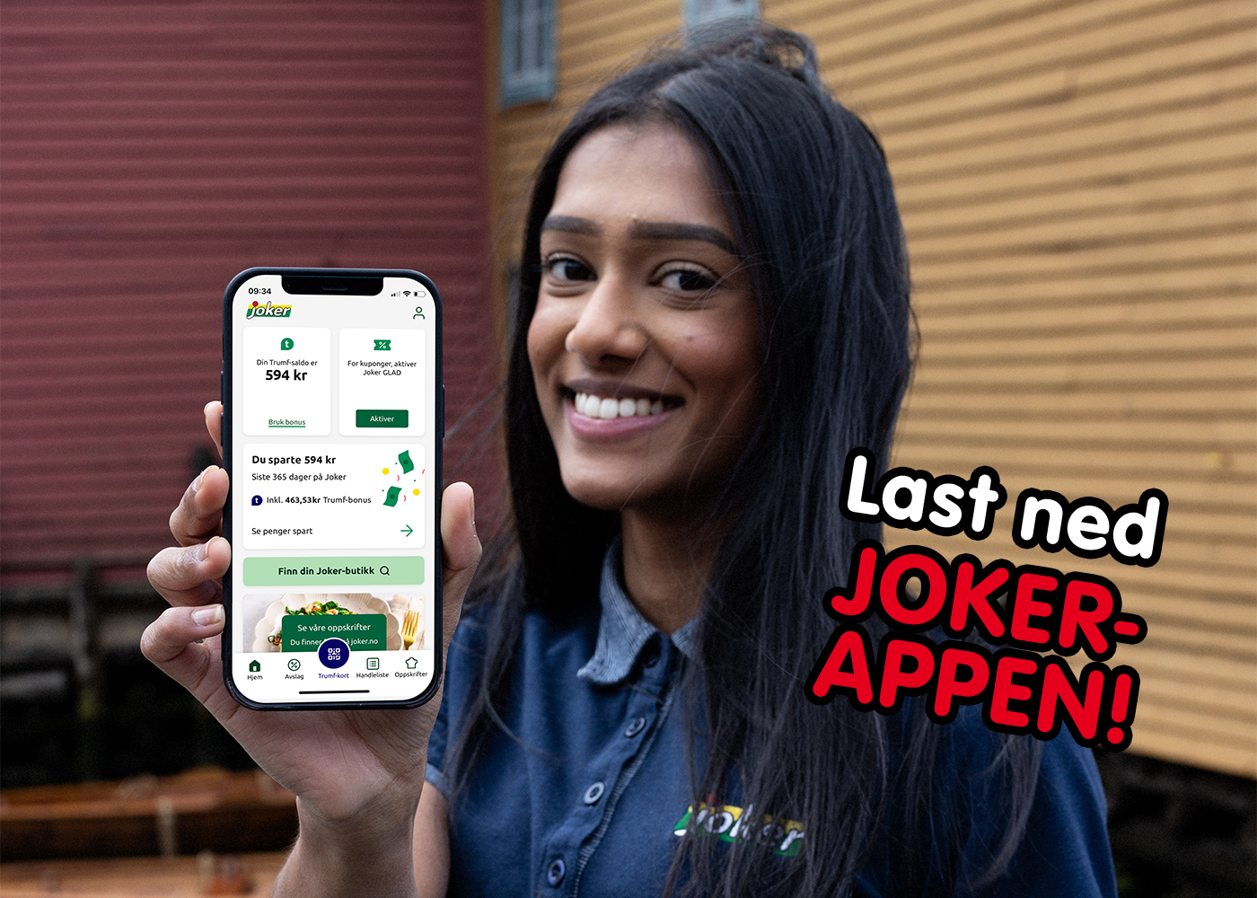 En kvinne i Joker-uniform holder opp en mobil som viser Joker-appen