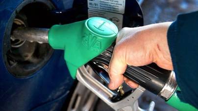 En hånd som fyller bensin på bil