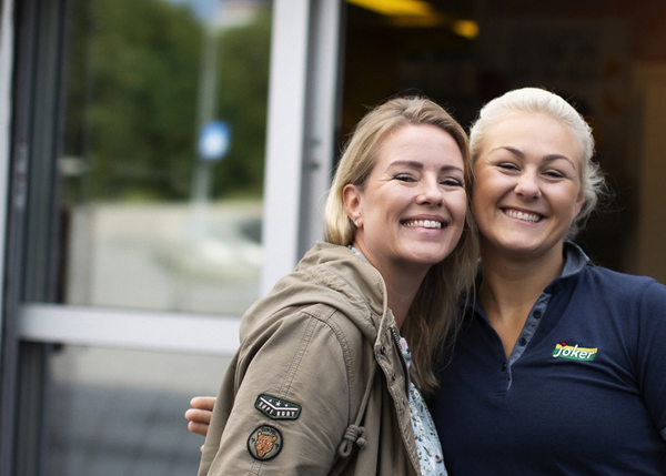 Smilende kunde og Joker-ansatt står sammen utenfor butikken