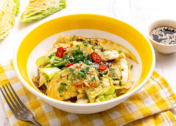 Asiatisk kålsalat med chili, urter og soyasaus servert i gul og hvit bolle