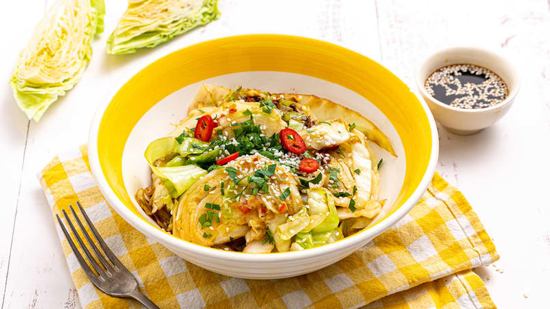 Asiatisk kålsalat med chili, urter og soyasaus servert i gul og hvit bolle