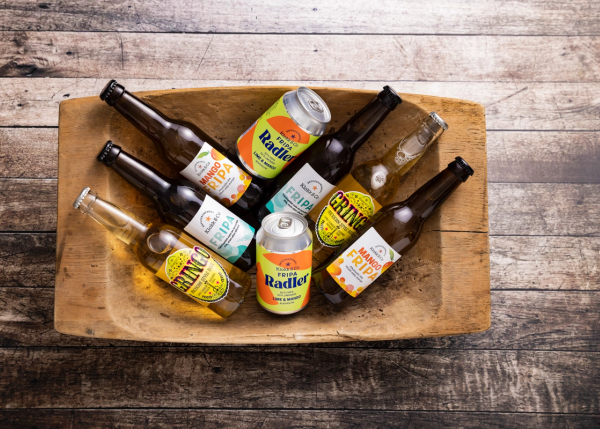 Flasker og bokser med Grans Radler og øl i en trefat