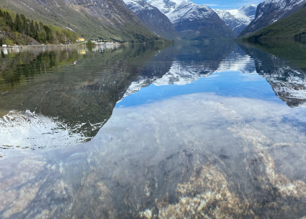Fantastiske fjell som speiler seg i vannet