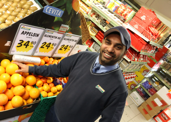 Kjøpmann Bhinder Singh poserer inne i butikken