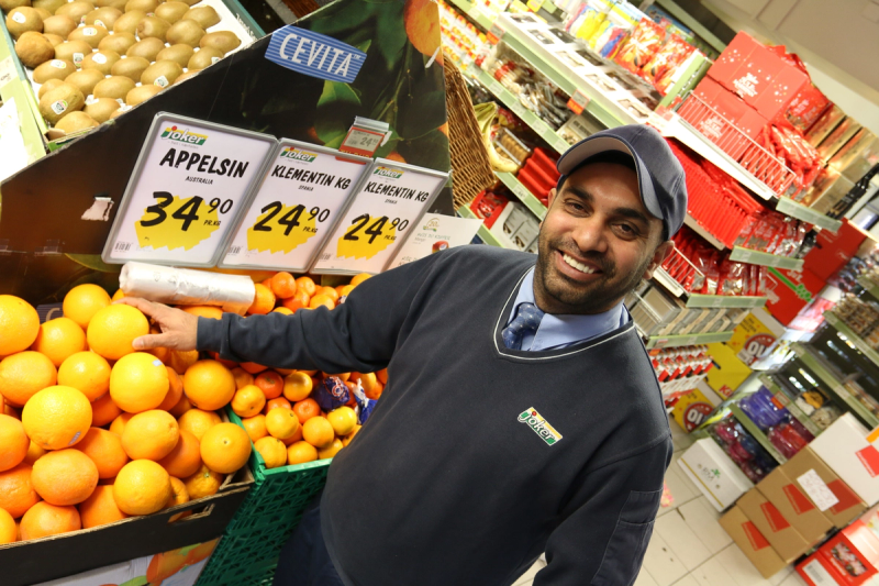 Kjøpmann Bhinder Singh poserer inne i butikken