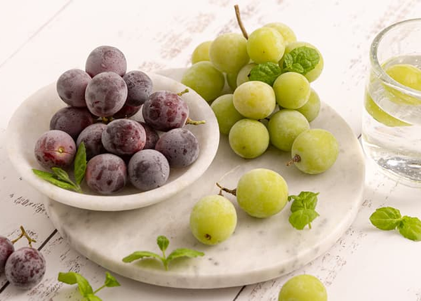 Grønne og røde druer på et fat