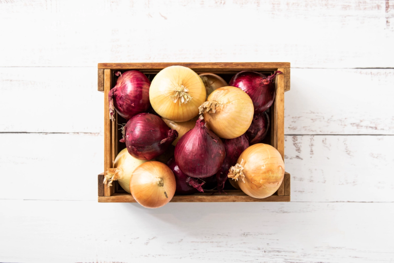 Rød og gul løk i kasse