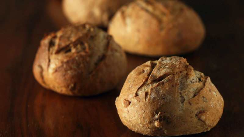 Nystekte grove rundstykker på trebord