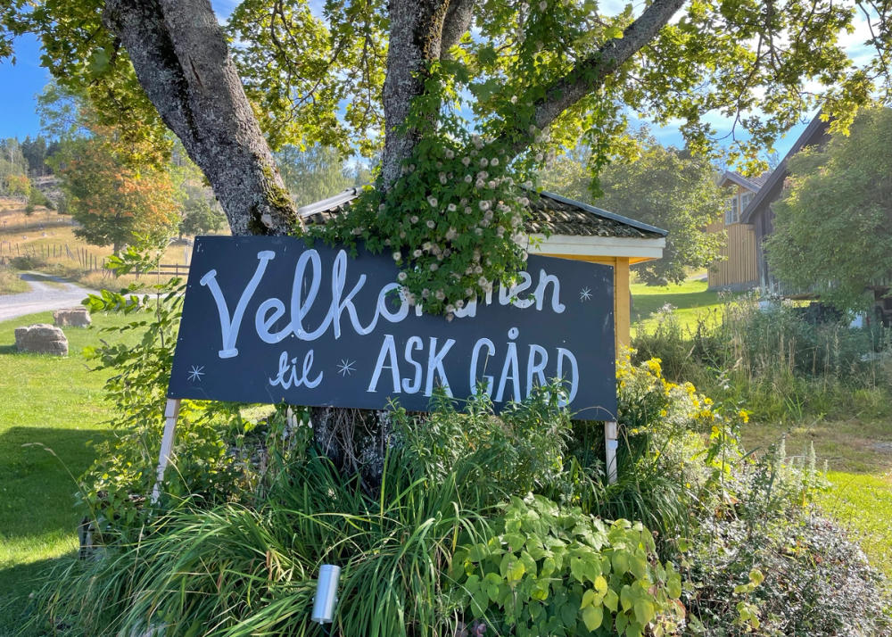 Et skilt som ønsker velkommen til Ask Gård