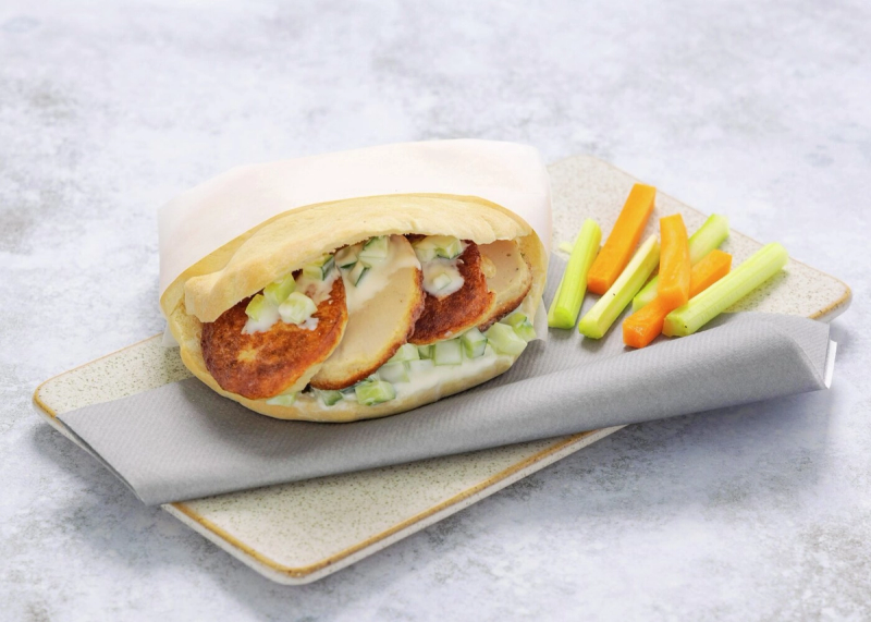 Pitabrød fylt med fiskekaker og grønnsaker, servert med staver av gulrot og selleri