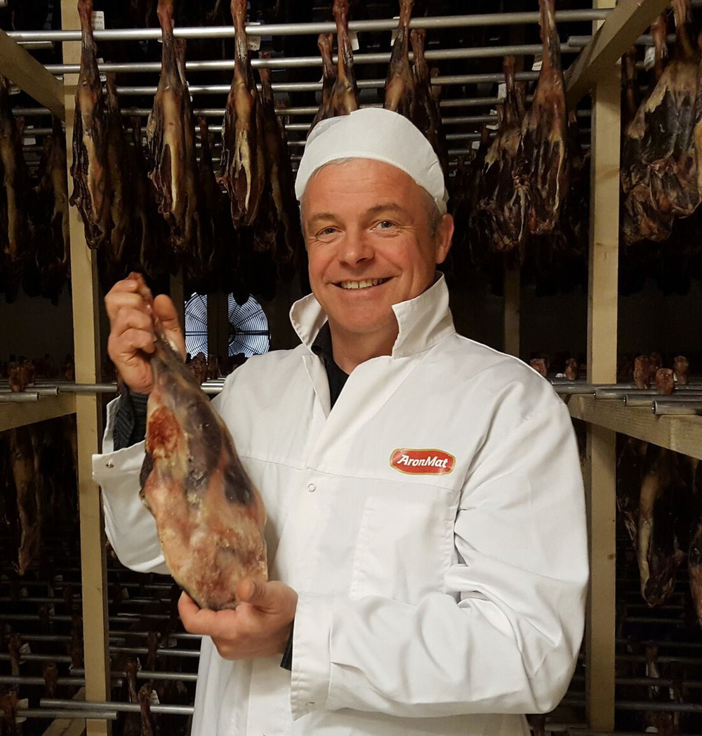 En stolt kjøttprodusent viser frem et fenalår