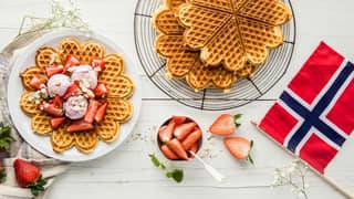 17. mai-feiring med vafler, jordbær, is og norsk flagg på bordet