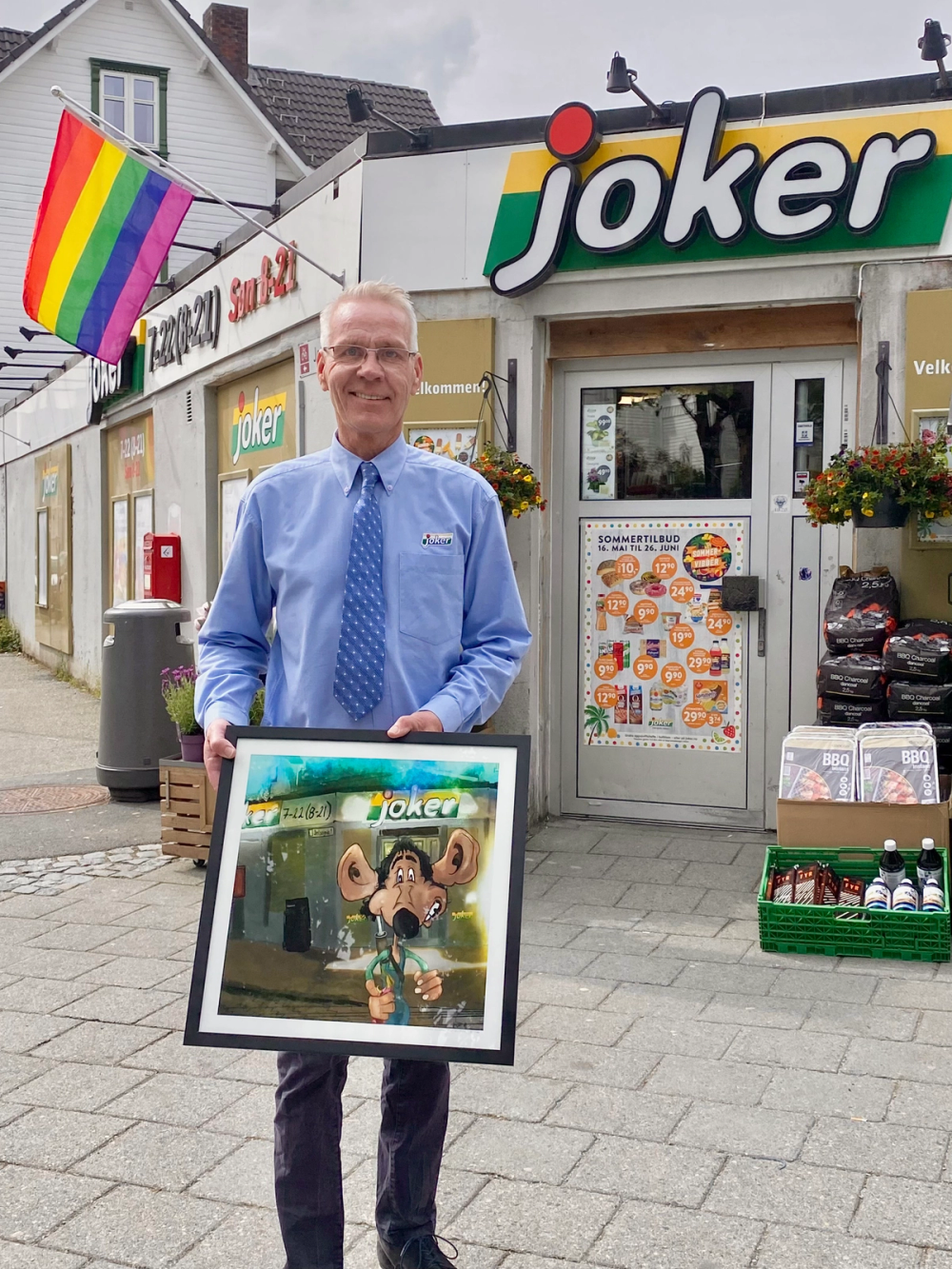 Geir Heim viser frem et kunstverk av butikken