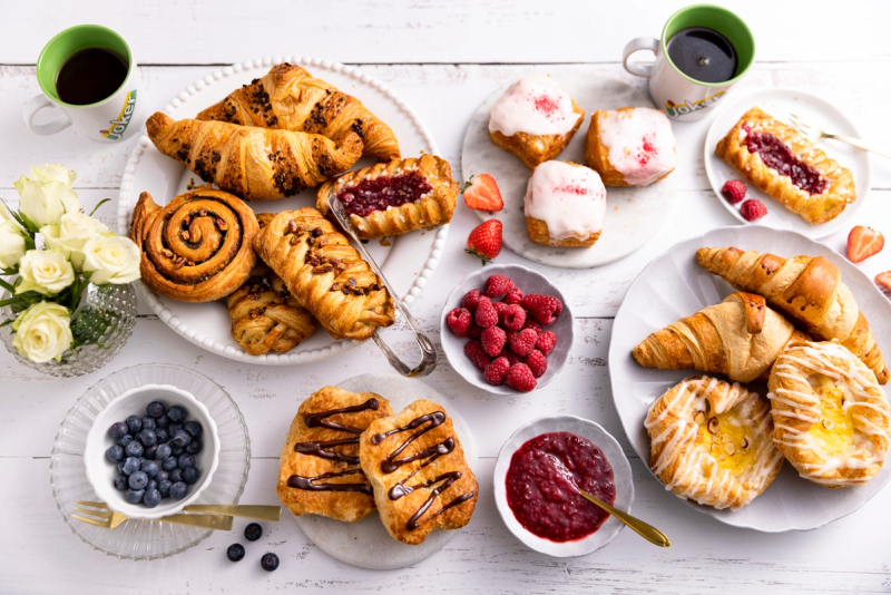 Bord med nystekte bakevarer og kaffe