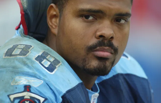 Erron Kinney, former Tennessee Titans tight end, wearing his #88 jersey on the sidelines during an NFL game, looking focused and determined.