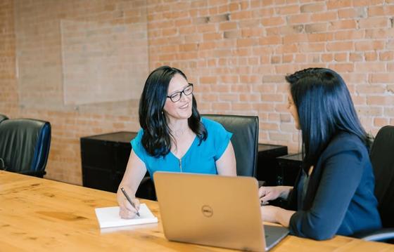 two female workers going through an onboarding process for new hire.