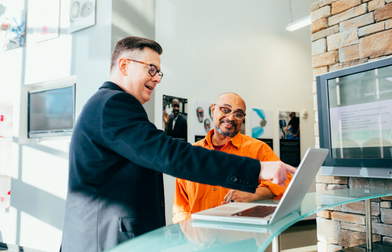 Two employees discussing workplace feedback data to improve employee sentiment and internal communications.